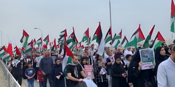 Citizens during a march in Salmabad carrying Palestinian flags