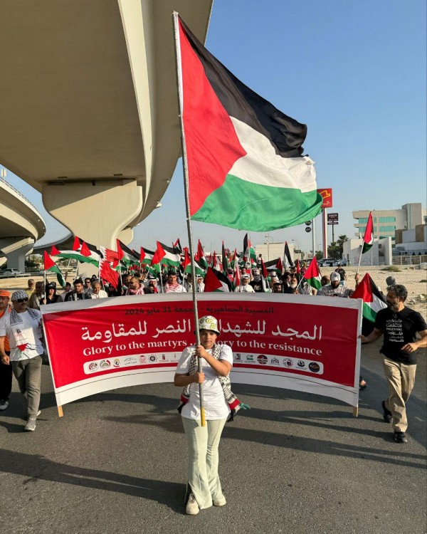 Participants in Manama rally holding Palestinian flags